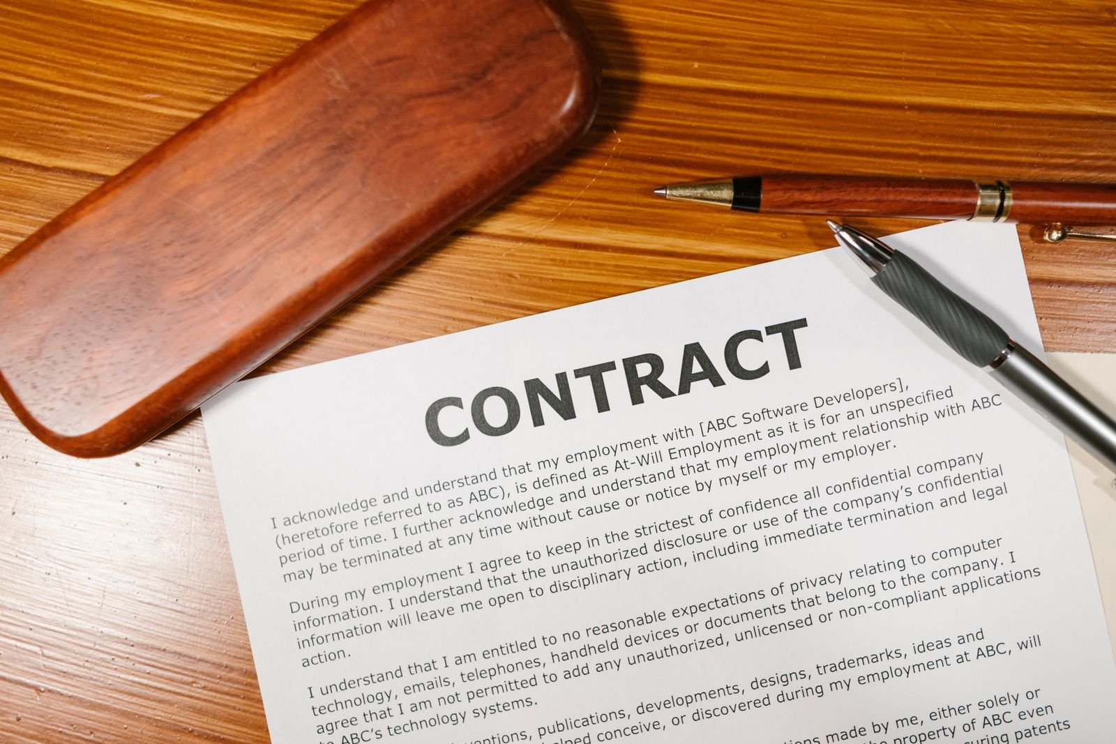 Commercial Title vs Residential Title in Malaysia: What Buyers Should Know 1 Overhead view of a printed property contract on a wooden desk with a pen resting beside it